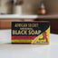 Bar of African Secret Original Black Soap on a surface with a blurred background