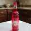 Bottle of cherry syrup with a red cap on a white background, featuring the brand 'Quince'.