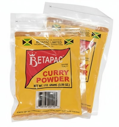 Two packages of Betapac Curry Powder, one in front and one behind, sealed in plastic, with yellow and red labeling and a green and red flag symbol.