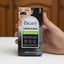 Biore control de grasa packaging held by a hand with a blurred background of various products.