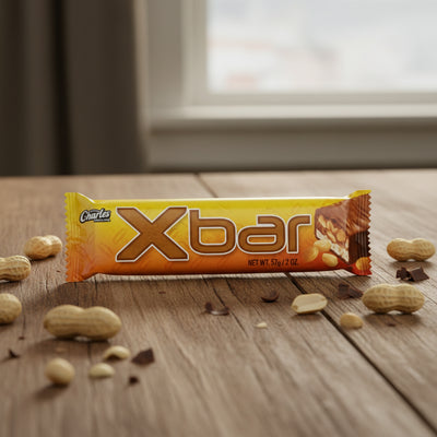 Yellow and brown Xbar protein bar packaging on a white background