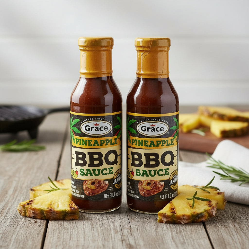 Bottle of Grace Pineapple BBQ Sauce on a wooden surface with pineapple slices and herbs.