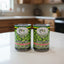 Cans of Goya green pigeon peas and other products on a shelf with a price tag.