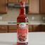 Bottle of strawberry flavored syrup with a visible brand label on a white background