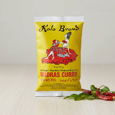 Kola Brand Madras Curry packet with a yellow background