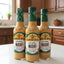 Three bottles of Mama Tere Aji con Mani hot sauce on a shelf with a price tag.