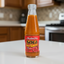 Bottle of Matouk's Soca hot sauce with a red label on a white background