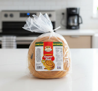 Packaged Jamaican sugar bun with a label on a black surface