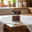 Packaged myrrh resin held by a hand with a blurred store shelf in the background