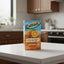 A 250 mL carton of Nestlé Orchard Fresh Squeezed Juicy Taste Orange drink, featuring a blue sky and wooden plank design with illustrations of whole and sliced oranges.