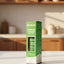 Hand holding a box of Nevada hair tonic with a blurred store shelf in the background