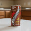 Nutrament energy nutrition drink can in chocolate flavor with 15g protein and 24 vitamins/minerals on a white background.