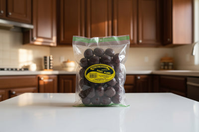 Bag of preserved sweet plums with a yellow label on a dark surface