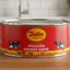 A can of Tastee Cheese, with a red background and an image of a cow. The can indicates a net weight of 1 kg and highlights that it is a product of America.