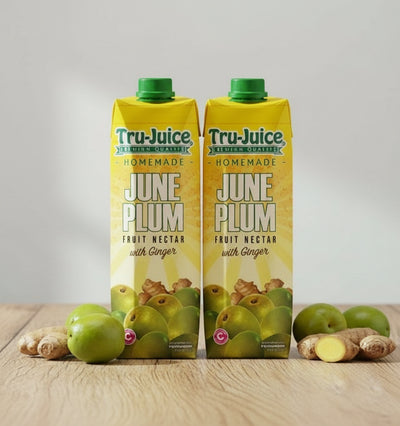 Tru Juice June Plum Fruit Nectar with Ginger on a wooden surface with plums and ginger.