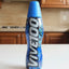 Blue energy drink bottle labeled 'Vivitoo Ultra' on a black surface with various items in the background.