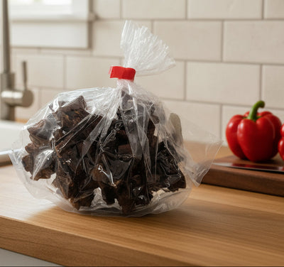 A plastic bag filled with Jamaican coconut drops, secured with a red clip.