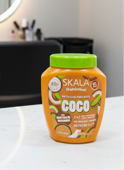 Skala Coco product jar with green lid on a beige background