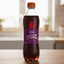Bottle of Uva Postobon soda with a purple label on a white background
