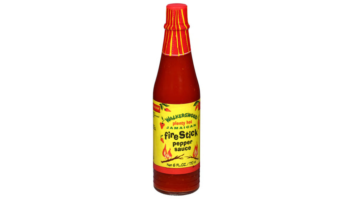 Bottle of Fire Stick pepper sauce with a red cap on a white background
